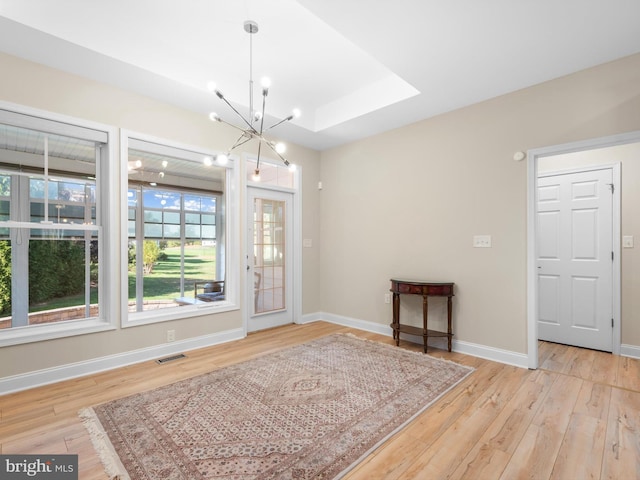 interior space with visible vents, baseboards, a notable chandelier, and wood finished floors