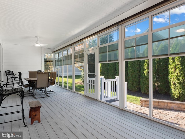 unfurnished sunroom featuring ceiling fan