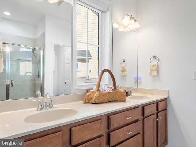 bathroom featuring double vanity, a stall shower, and a sink