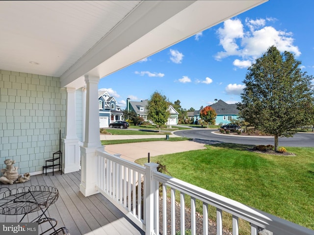 wooden terrace with a porch, a yard, and a residential view