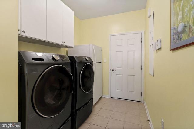 laundry room with light tile patterned floors, cabinets, and washer and dryer