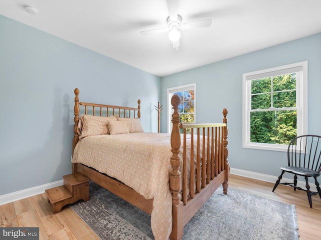 bedroom with a ceiling fan, baseboards, and wood finished floors