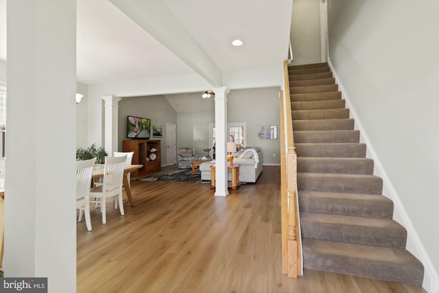 foyer with lofted ceiling, light hardwood / wood-style flooring, and decorative columns