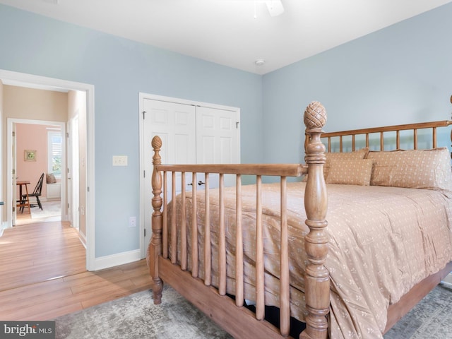 bedroom with a closet, baseboards, and wood finished floors