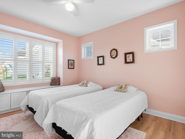 bedroom featuring baseboards, light wood finished floors, and ceiling fan