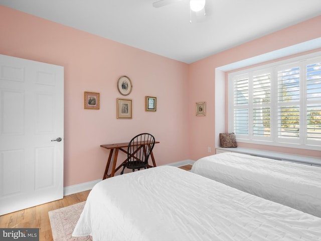 bedroom with ceiling fan, baseboards, and wood finished floors