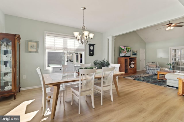 dining room featuring ceiling fan with notable chandelier, vaulted ceiling, ornate columns, and light hardwood / wood-style floors