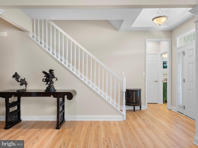 foyer featuring stairway, baseboards, and wood finished floors