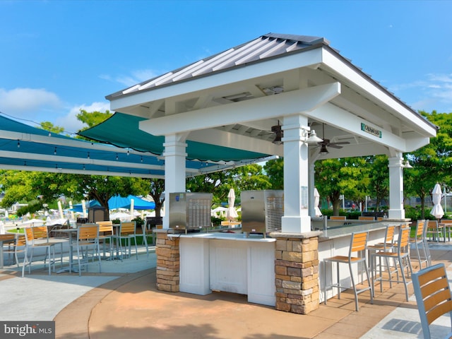 view of patio with a gazebo, exterior kitchen, outdoor wet bar, and a ceiling fan