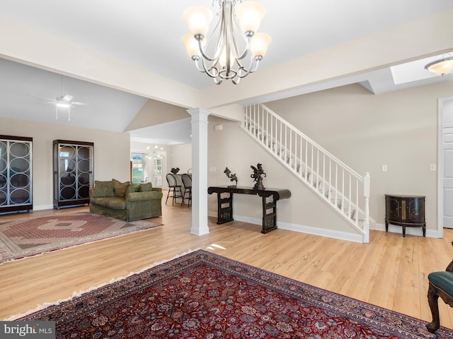 interior space with stairway, decorative columns, lofted ceiling, and wood finished floors