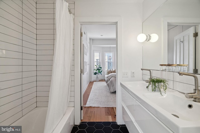 bathroom with shower / bath combo, hardwood / wood-style floors, and vanity