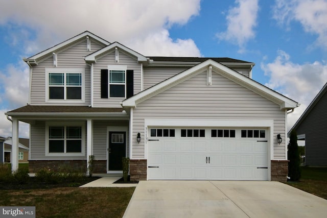 view of front facade featuring an attached garage, concrete driveway, and stone siding