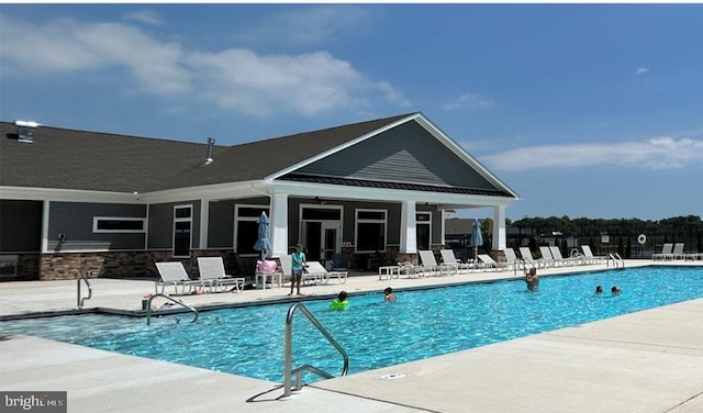 community pool with a patio area and fence