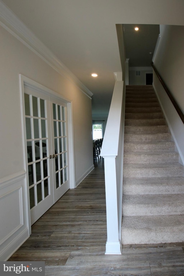 staircase featuring ornamental molding, french doors, and hardwood / wood-style flooring