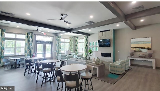 dining space featuring beam ceiling, visible vents, and plenty of natural light