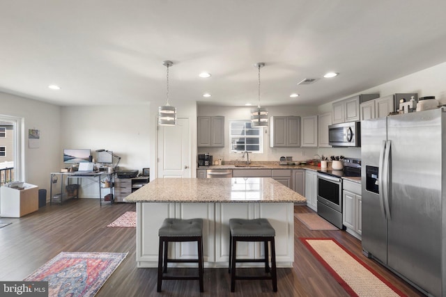 kitchen featuring stainless steel appliances, gray cabinets, visible vents, dark wood-type flooring, and a sink