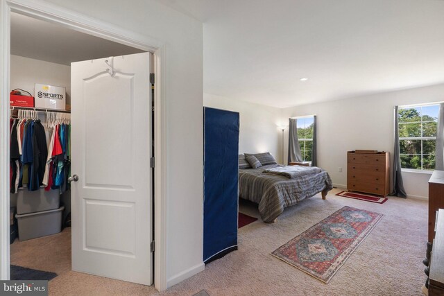 bedroom with light carpet and a closet