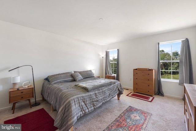 bedroom with baseboards and light colored carpet