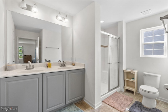 full bathroom with visible vents, a sink, a shower stall, and toilet