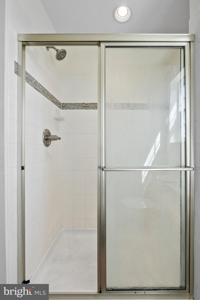 bathroom featuring a shower with door