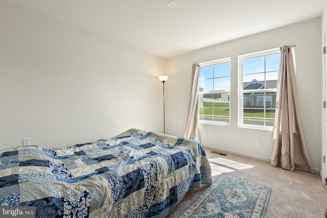 carpeted bedroom with visible vents and baseboards