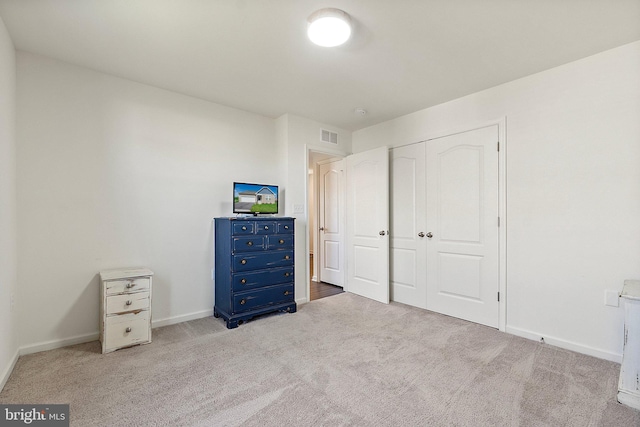 unfurnished bedroom featuring baseboards, carpet, visible vents, and a closet