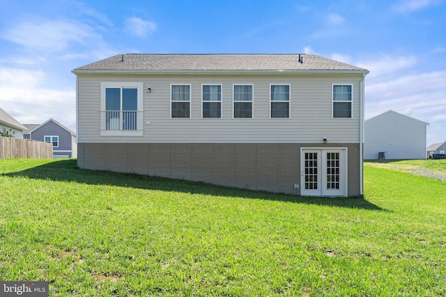 back of property with a lawn and french doors