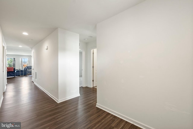 hallway with baseboards, dark wood-type flooring, and recessed lighting