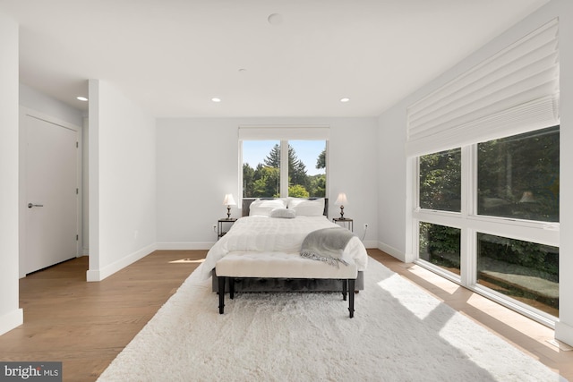 bedroom with recessed lighting, wood finished floors, and baseboards