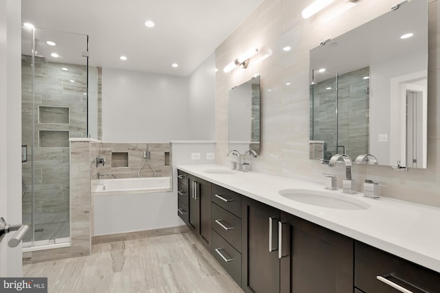 bathroom with double vanity, a bath, a stall shower, and a sink