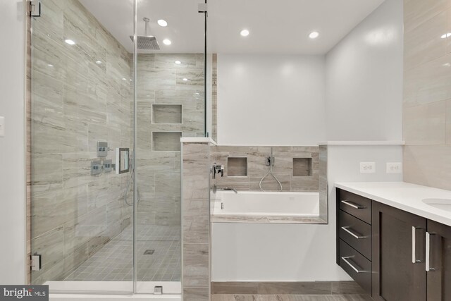 bathroom featuring tiled shower and vanity