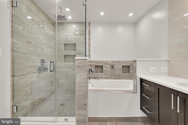 full bathroom featuring a bath, recessed lighting, a stall shower, and vanity