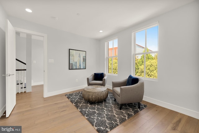 living area featuring recessed lighting, baseboards, and light wood-type flooring