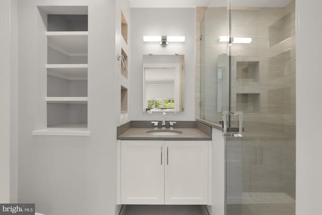 bathroom with vanity, a shower stall, and built in shelves