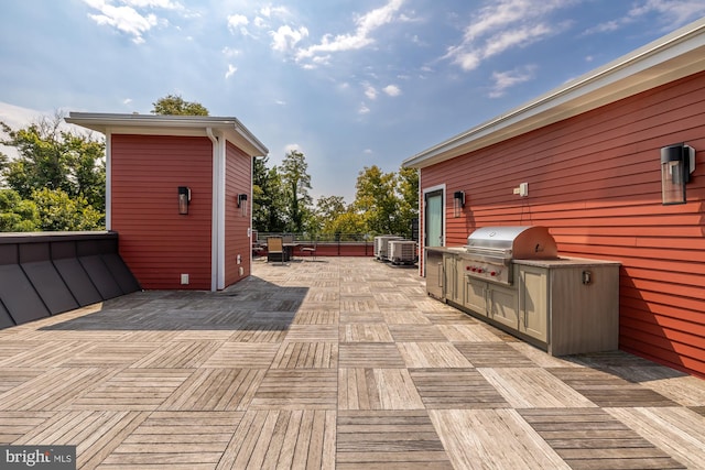 exterior space with grilling area, an outdoor kitchen, and central air condition unit