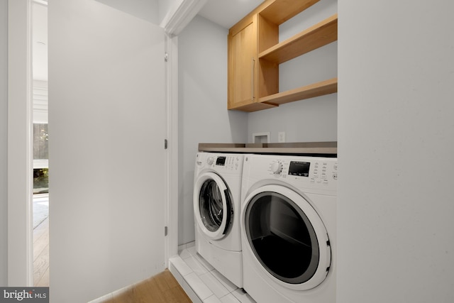 washroom with cabinet space and washing machine and clothes dryer