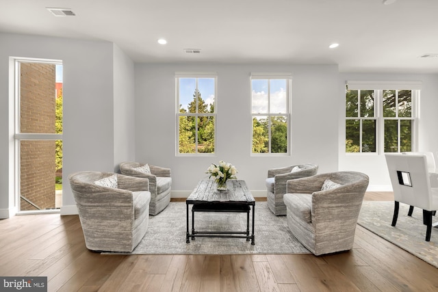 sitting room with recessed lighting, visible vents, and wood-type flooring