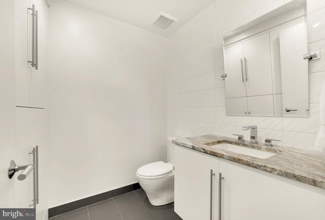 bathroom featuring vanity, toilet, and tile patterned flooring