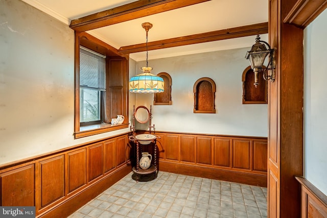 interior space with ornamental molding and beam ceiling