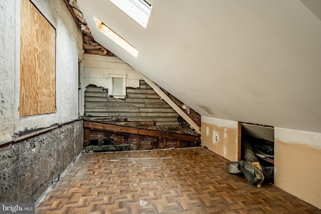 additional living space featuring vaulted ceiling with skylight and dark parquet flooring