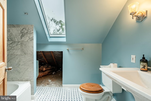 bathroom featuring vaulted ceiling with skylight, a tub, and toilet