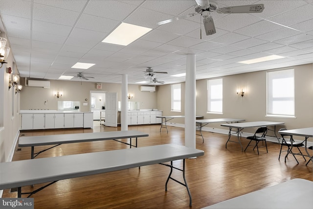 dining area with ceiling fan, light hardwood / wood-style floors, and a wall mounted air conditioner