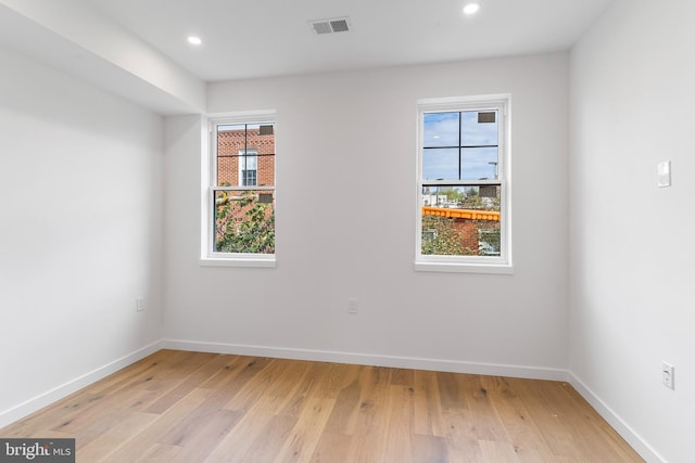 spare room with a healthy amount of sunlight and light hardwood / wood-style floors