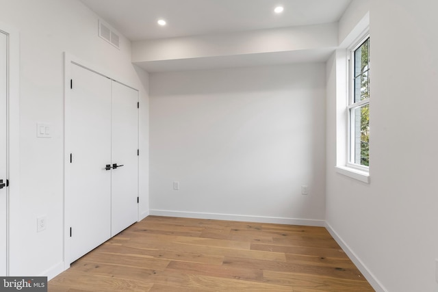 unfurnished bedroom with light wood-type flooring and multiple windows