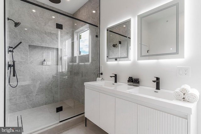 bathroom featuring a shower with door and vanity