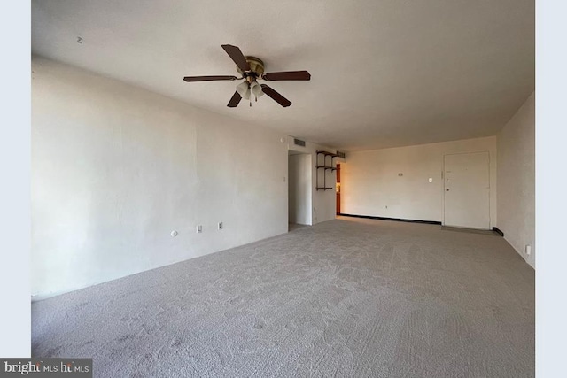 empty room featuring visible vents, a ceiling fan, and carpet flooring