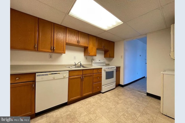 kitchen featuring washer / clothes dryer, a paneled ceiling, white appliances, and sink