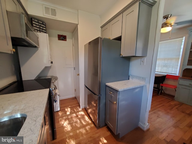 kitchen featuring gray cabinets, appliances with stainless steel finishes, light wood finished floors, and a ceiling fan