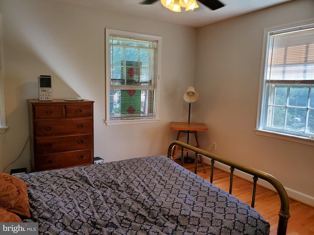 bedroom with baseboards and wood finished floors
