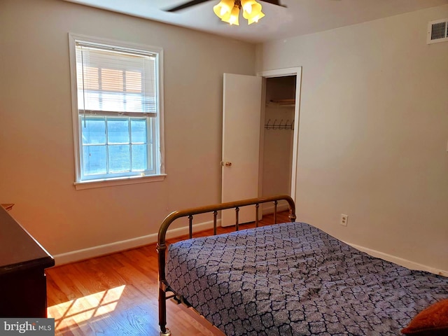 bedroom with visible vents, baseboards, ceiling fan, and wood finished floors